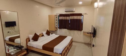 a hotel room with two beds and a bathroom at Aquarius Resort in Pune