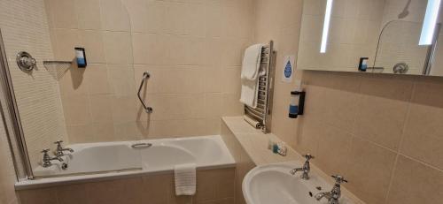 a bathroom with a sink and a bath tub at Moyvalley Hotel & Golf Resort in Moyvalley