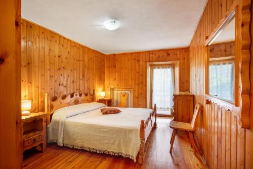 a bedroom with wooden walls and a bed in a room at Maison Marcel Sarre in Aosta