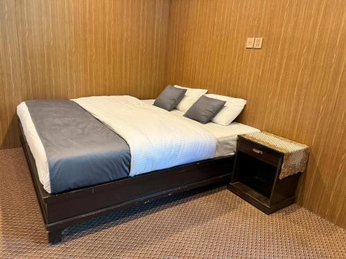 a bed with two pillows on it in a room at The Hermes Hotel & Backpackers Hostel in Minapin