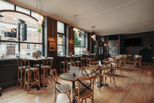 a restaurant with tables and chairs and windows at Yorkshire Grey Pub & Rooms in London
