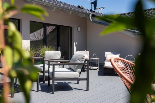 a patio with chairs and a table and a table and chairs at Ostsee Apartmenthotel in Graal-Müritz