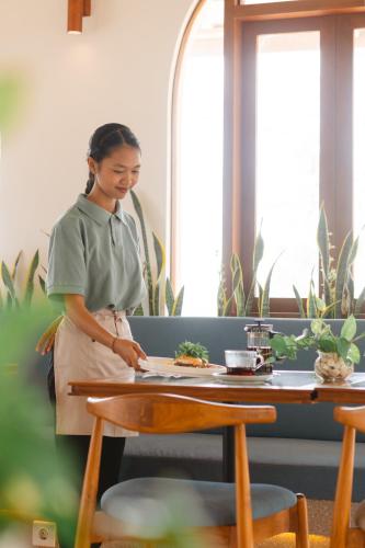 a woman in an apron standing next to a table at Arpana Luxury Private Pool Villas in Jimbaran