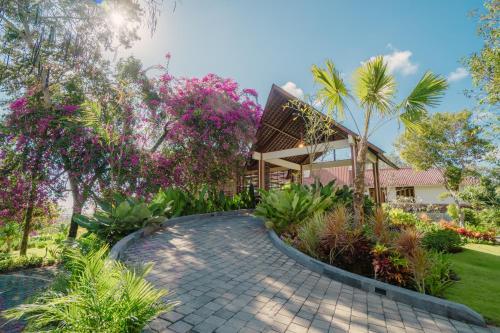 a walkway in front of a house with trees and flowers at Arpana Luxury Private Pool Villas in Jimbaran