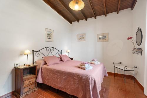 a bedroom with a bed with a pink bedspread at Casa Afortunada in Hermigua