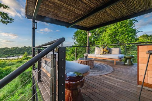 a deck with a couch and a chair on a wooden deck at Elephant Point in Skukuza