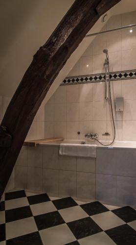 a bathroom with a shower and a bath tub at Hotel De Limbourg in Sittard