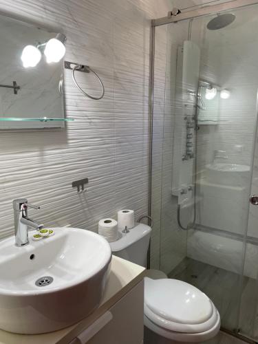 a bathroom with a sink and a toilet and a shower at Limnionas Bay Village Hotel in Marathokampos