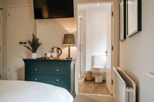 a bedroom with a blue dresser and a toilet at The Swinside Inn in Keswick