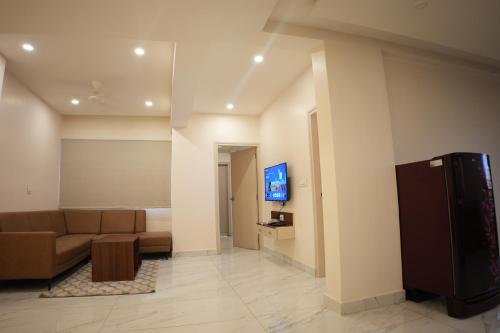 a living room with a couch and a tv in a room at AK Castle Suites in Bengaluru
