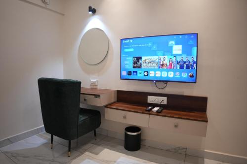 a television on a wall in a room with a chair at AK Castle Suites in Bengaluru