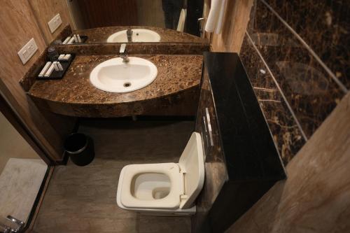 a bathroom with a sink and a toilet at AK Castle Suites in Bengaluru