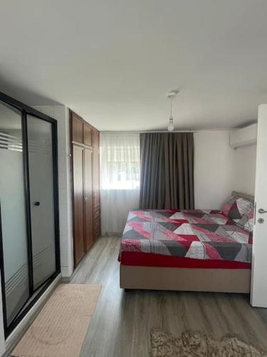 a bedroom with a bed with a red comforter at Girne KKTC in Ayyorgi