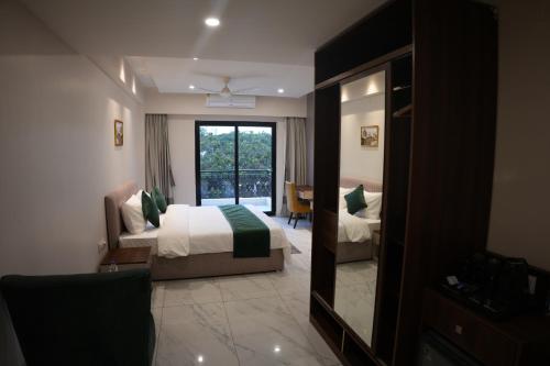 a hotel room with a bed and a mirror at AK Castle Suites in Bengaluru