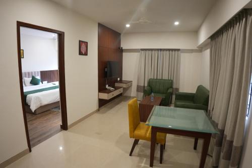 a hotel room with a table and a bedroom at AK Castle Suites in Bengaluru