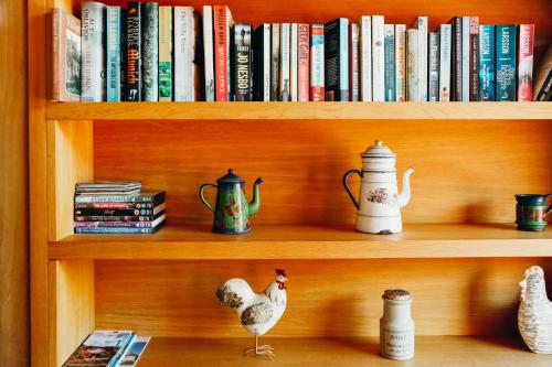 a book shelf with books and ducks on it at Le Cochet by Lodji in Saint-Martin-de-Belleville