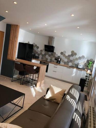 un salon avec un canapé et une cuisine dans l'établissement Etaples maison de ville , maison de pêcheur, à Étaples