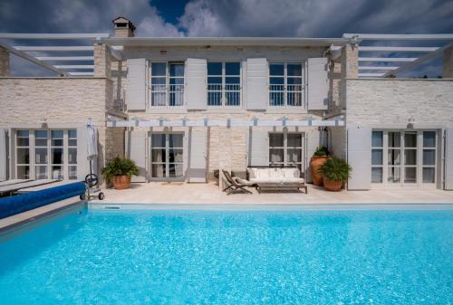 a house with a swimming pool in front of a house at Villa Moonlight 1 near Poreč for 9 person - pet friendly with large garden, playground & 50 m2 pool in Višnjan