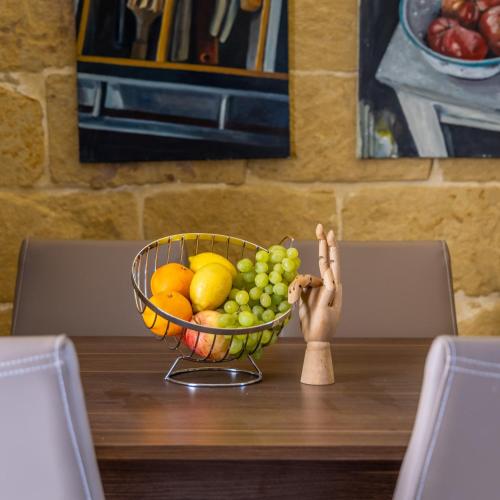 a bowl of fruit sitting on a table with a wooden stick at Room 6 - Family room x 3 by Solea in Għarb