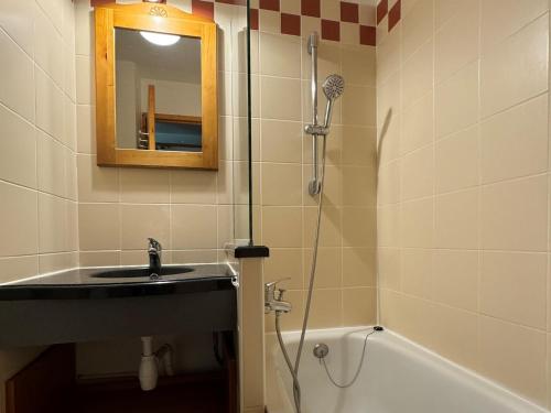 une salle de bain avec un lavabo et une douche avec un miroir dans l'établissement Studio cosy au pied des pistes avec balcon et casier à skis - FR-1-181-2034, à La Plagne Tarentaise