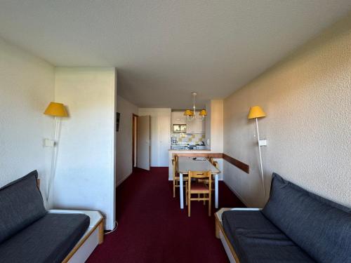 une chambre avec deux lits, une table et une cuisine dans l'établissement Appartement au pied des pistes avec WIFI et animaux admis - FR-1-181-2247, à La Plagne Tarentaise