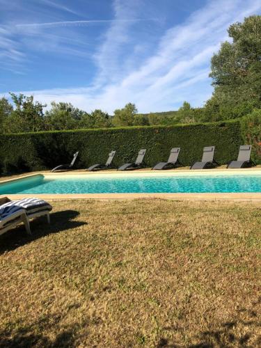 - une piscine avec des chaises longues dans la cour dans l'établissement Maison de 1820 dans un écrin de verdure de 2 ha, à Entrechaux