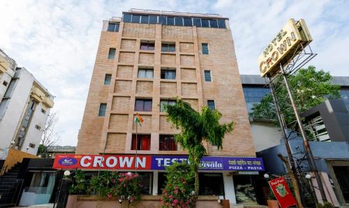 a tall building with a sign in front of it at Hotel Crown in Ahmedabad