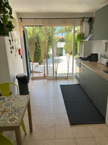 a kitchen with a table and a view of a patio at A Casa da Lagoa de Albufeira in Sesimbra