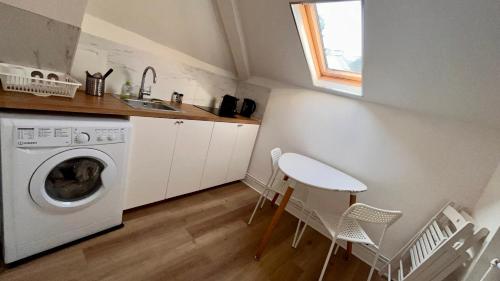 a kitchen with a washing machine and a table and chairs at Europole 2 Gare de Grenoble & centre ville in Grenoble