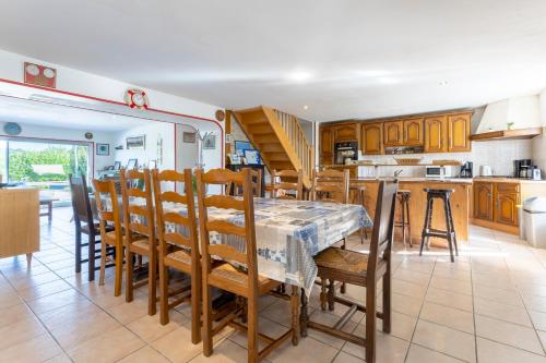 une cuisine et une salle à manger avec une table et des chaises dans l'établissement Maison familiale 800m de la plage, à Penmarcʼh