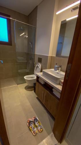 a bathroom with a sink and a shower and a toilet at Wateera Jebel Sifah in As Sīfah