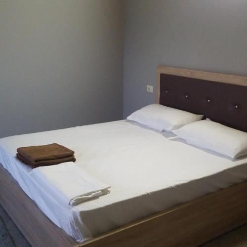 a bed with two white pillows and a wooden headboard at Hotel Culaj in Koplik
