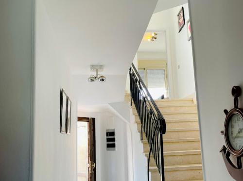 a hallway with a staircase with a clock on the wall at Spacious Villa lake view 6 Bedrooms Einbay Resort in Ain Sokhna