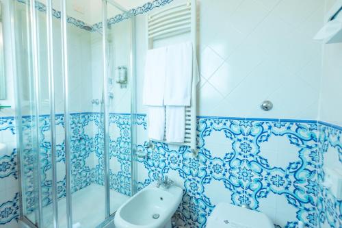 a blue and white bathroom with a tub and a sink at Hotel Villa Sarah in Capri