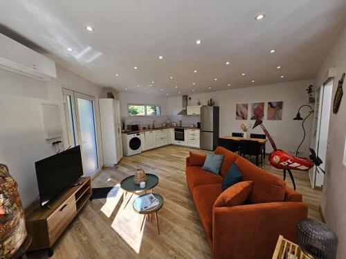 un salon avec un canapé et une télévision dans l'établissement GÎTE Le PETRUS, à Balaruc-les-Bains