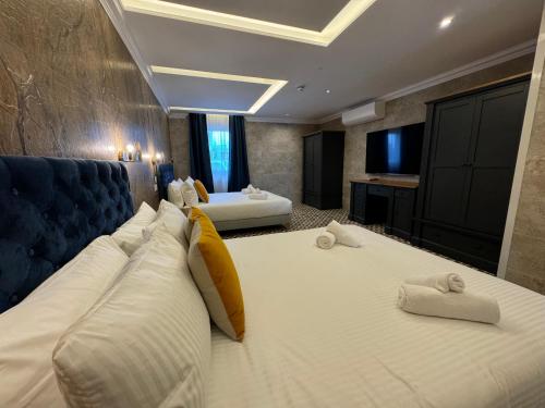 a hotel room with two beds and a television at Balcony Hotel in St Julian's