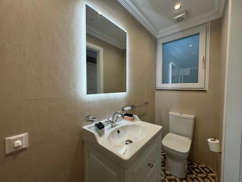a bathroom with a sink and a toilet and a mirror at Balcony Hotel in St Julian's