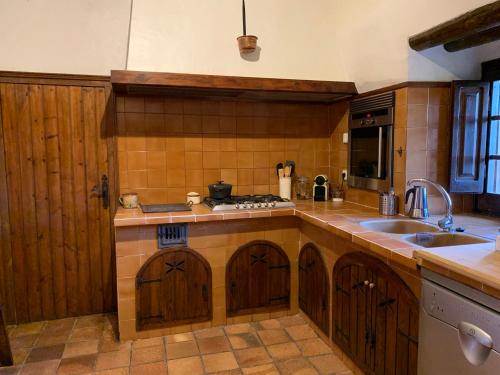 a kitchen with a sink and a stove top oven at Els Racons del Fort Castle hosting up to 18 people in Capmany