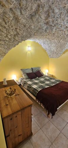 une chambre avec un lit et un mur en pierre dans l'établissement Maison cosy à la montagne, à La Chalp