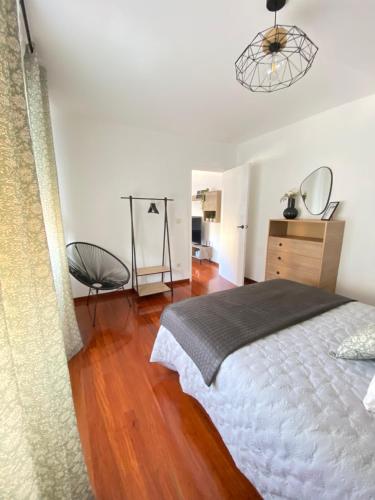 a bedroom with a bed and a wooden floor at Aloha T in Porriño