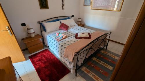 una camera con un letto e un tappeto rosso di Appartamento a Fossato di Vico a Fossato di Vico