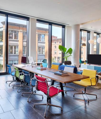 an office with a long table with colorful chairs at citizenM Boston Back Bay in Boston