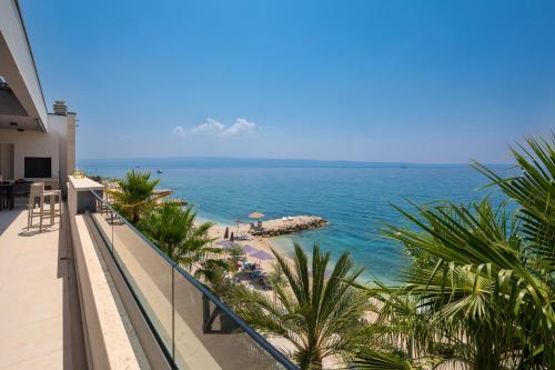 a view of the beach from the balcony of a hotel at Paoma Luxury Beach Suite with jacuzzi in Podstrana