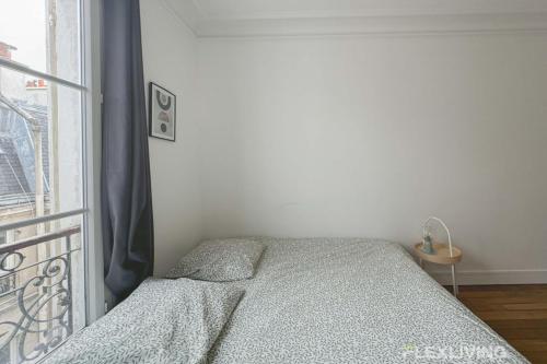 a bedroom with a bed next to a window at Flexliving - room - Lemoine in Paris