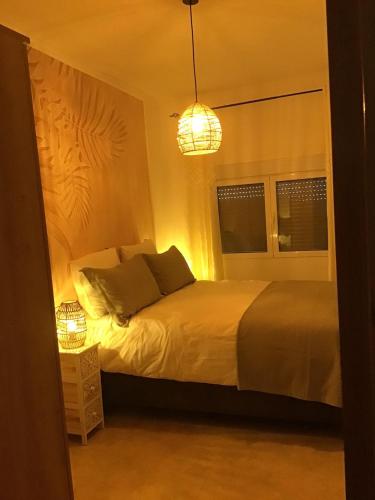 a bedroom with a bed and a chandelier at Cortijo Los Corazones in Cantoria