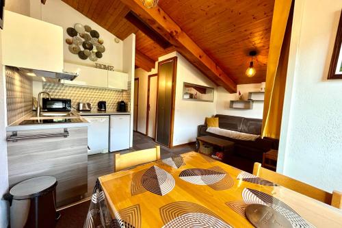a kitchen and dining room with a table in a room at Les Cimes Princières in Demi-Quartier