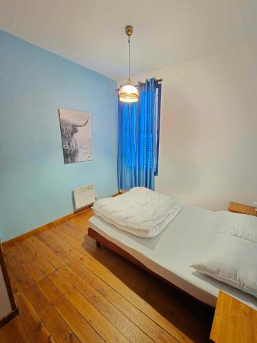 Un dormitorio con una cama grande con una pared azul. en Maison Titiane, en Mers-les-Bains