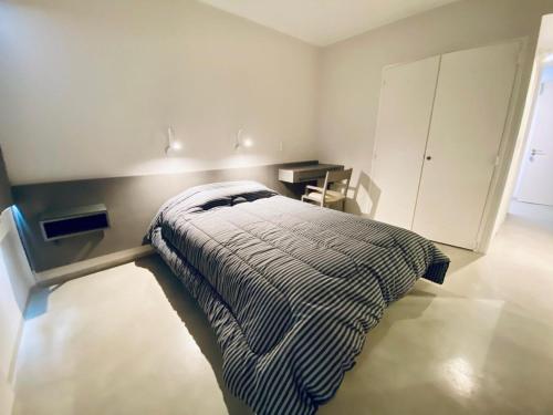 a bedroom with a bed in a white room at ALWA Suites in Resistencia