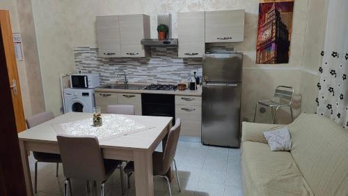 カターニアにあるAlle Porte Del Pigno Houseのテーブルと冷蔵庫のある小さなキッチン