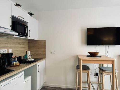 une cuisine avec une petite table et deux tabourets dans l'établissement Le TerraRosa, studio à Rennes, à Chantepie